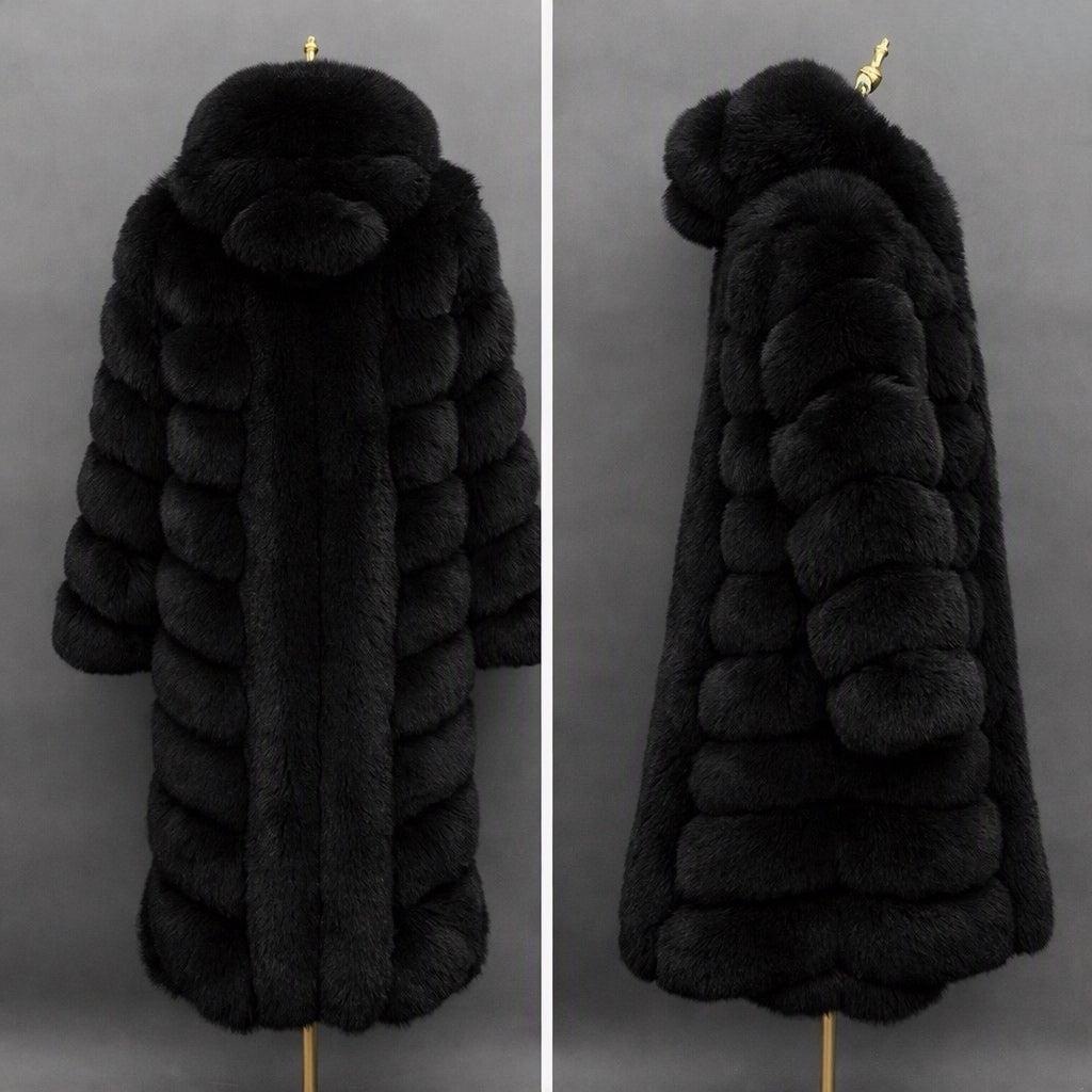 A long black fur coat displayed on a mannequin against a dark gray background, shown from the back on the left and side on the right. The coat features a large plush hood with a matching pom-pom detail and horizontal padded paneling.